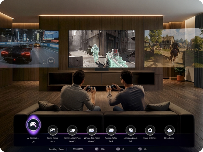 남성 두명이 소파에 앉아서 게임을 하고 있습니다. TV 화면에는 게임 화면이 보여지고 있습니다.